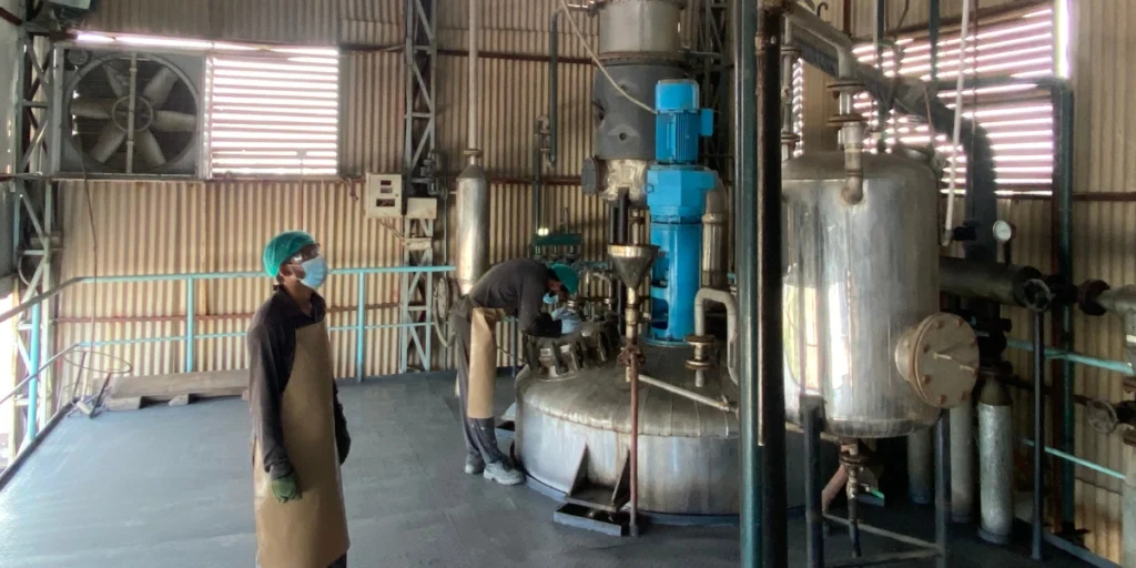 Workers operating industrial reactor equipment highlighting Toll Manufacturing Benefits for startups in Pakistan.
