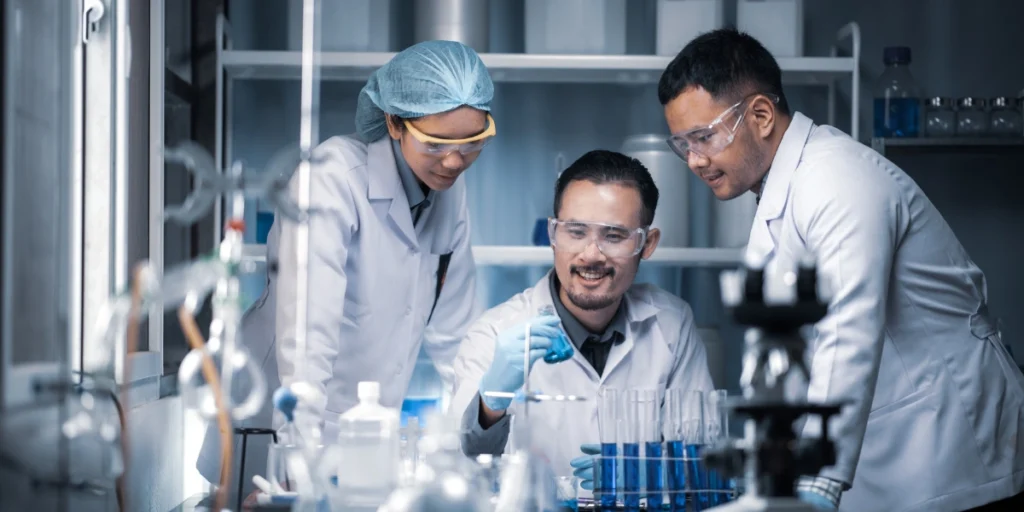 Team of lab scientists collaborating on chemical manufacturing, representing a zero investment company Pakistan delivering scalable production solutions.