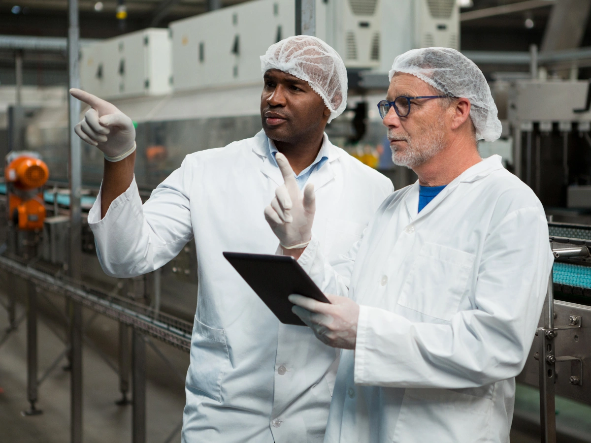 Engineers reviewing production processes on a tablet in a third-party chemical manufacturing facility.